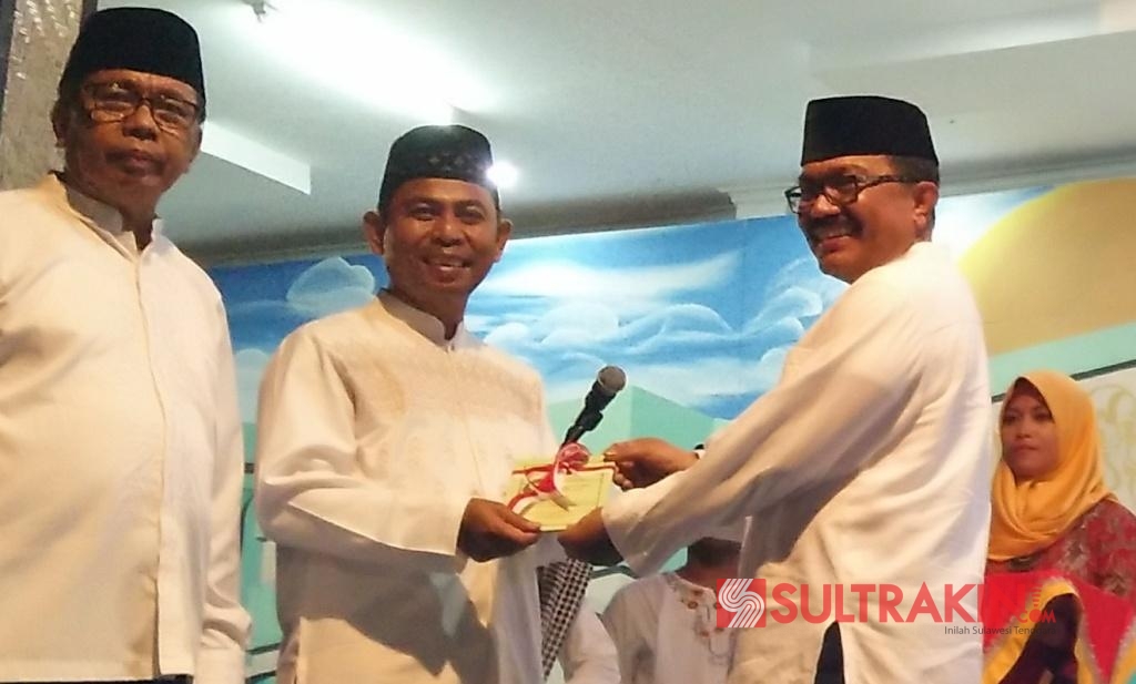 Bupati Wakatobi, Arhawi menyerahkan Perda Nomor 14 Tahun 2012 tentang penuntasan buta aksara dan baca tulis Al Quran. (Foto: Amran Mustar Ode/SULTRAKINI.COM)