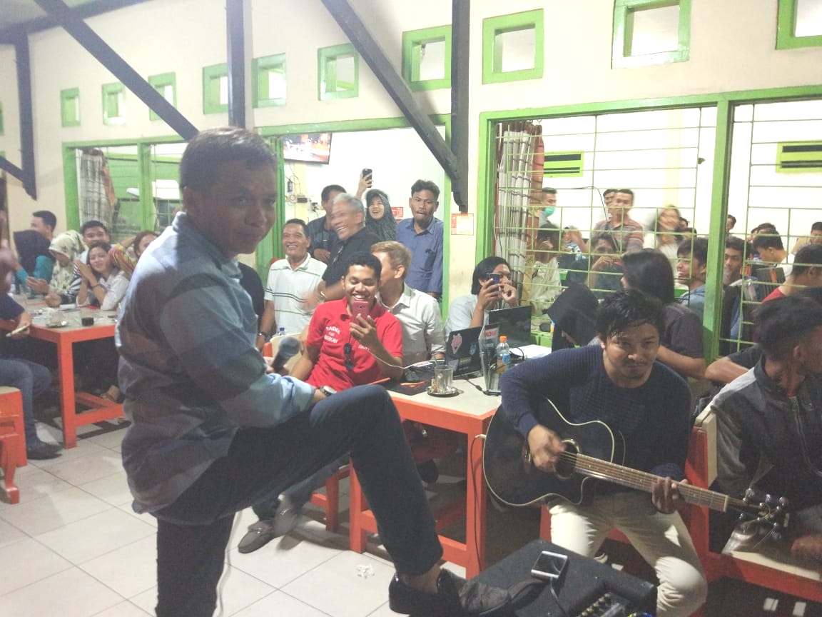 Abdurrahman Saleh menyanyikan lagu Bento diiringi petikan gitar dari Zhul Zhivilia di Warkop Haji Unding Kota Lama, Selasa (15/5/2018) malam. Foto: Gugus Suryaman/SULTRAKINI.COM