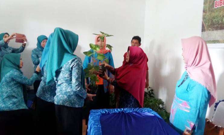 Kepala Dinas Pertanian Kota Kendari bersama jajarannya saat menyerahkan bantuan bibit kepada pengurus kelompok dasar wisma di Kelurahan Pudai, Kecamatan Abeli, Kamis (24/5/2018). (Foto: Hasrul Tamrin/SULTRAKINI.COM)