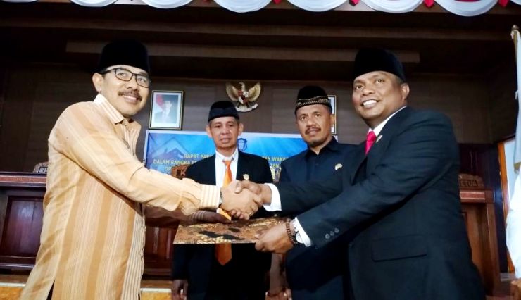 Ketua DPRD Wakatobi, Muhamad Ali menyerahkan rekomendasi DPRD ke Sekda Wakatobi, Muh. Ilyas Abibu. (Foto: Amran Mustar Ode/SULTRAKINI.COM)