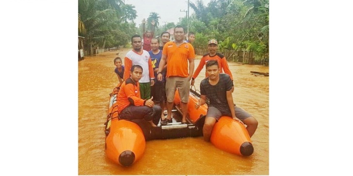 Kepala BPBD Muna, Laode Ibrar Rifai bersama TRC, saat membantu mengevakuasi korban banjir. (Foto: Arto Rasyid/SULTRAKINI.COM)