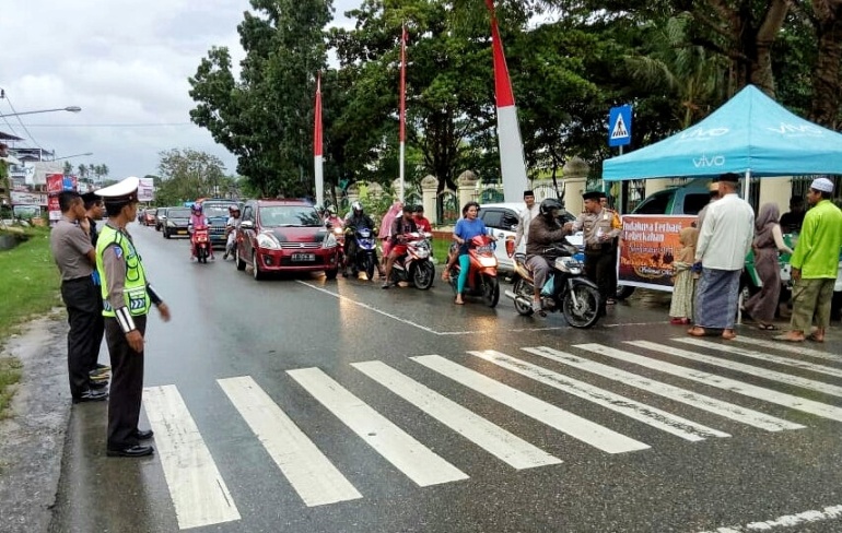 Kapolres Muna, AKBP Agung Ramos Paretongan Sinaga bersama Waka Polres Muna, Kompol Yusuf Mars saat berbagi takjil gratis kepada pengguna jalan. (Foto: Arto Rasyid/SULTRAKINI.COM)