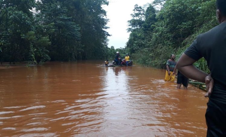 Sejumlah warga mencoba menerobos banjir di Desa Polara Indah, Kecamatan Langgikima ,Kabupaten.Konawe Utara, Sultra. ( Foto: sulham tepamba/SULTRAKINI.COM)