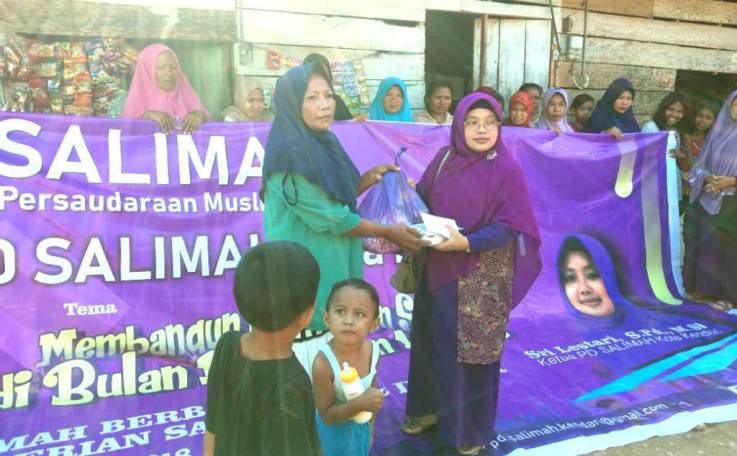 Ketua PD Salimah Kota Kendari, Sri Lestari memberikan paket sembako kepada warga kurang mampu di wilayah setempat, Jumat (8/6/2018). (Foto: Rifin/SULTRAKINI.COM)