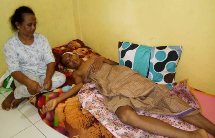 Muhamad Irwan Alhanaf yang sedang berbaring sakit di kos-kosan Kelurahan Kadolomoko (kanan) yang didampingi Ibu Kandungnya Nafsiah (kanan), pada (10/6/2018). (Foto/ Zarmin/SULTRAKINI.COM)