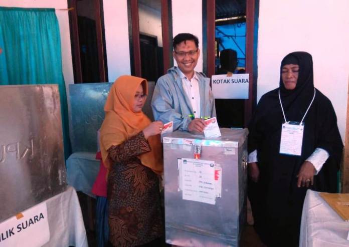 Plt Walikota Kendari Sulkarnain didampingi istrinya saat menyalurkan hak suaranya di TPS 04 Korumba (Foto : Hasrul Tamrin/SULTRAKINI.COM)