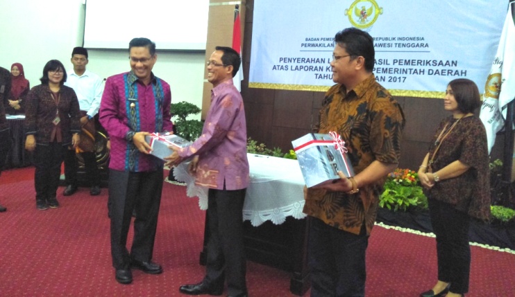 Pelaksana Tugas Wali Kota Kendari, Sulkarnain menerima LKPD 2017 dari Kepala Perwakilan BPK Sultra, Hermanto.(Foto:Nur Cahaya/SULTRAKINI.COM)