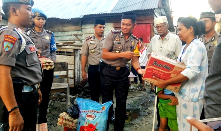 Kapolres Muna, AKBP Agung Ramos Paretongan Sinaga bersama rombongan saat memberikan bantuan sembako kepada purnawirawan Polisi, Arif. (Foto: Arto Rasyid/SULTRAKINI.COM)