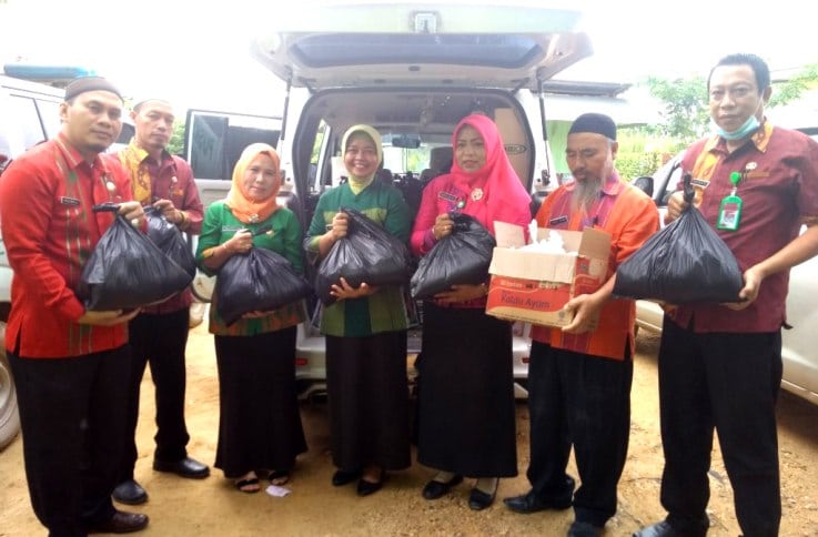 Jajaran Dinas Kesehatan Kota Kendari membagikan bantuan paket sembako di empat kelurahan, Kamis (7/6/2018). (Foto: Hasrul Tamrin/SULTRAKINI.COM)