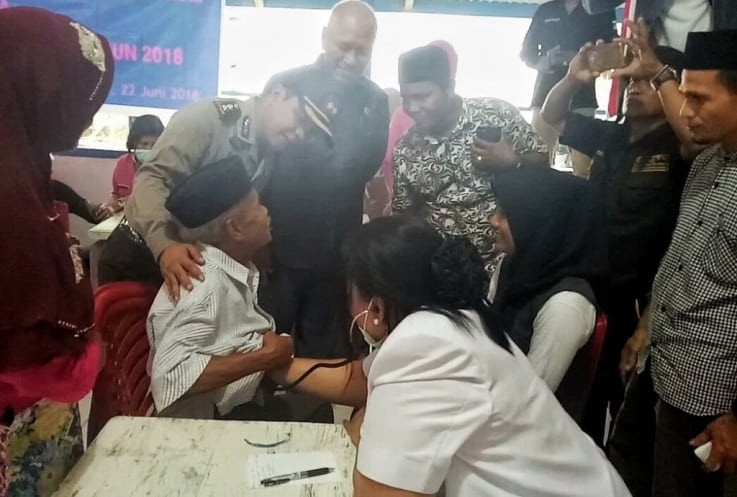 Kapolres Muna, AKBP Agung Ramos Paretongan Sinaga bersama Kadinkes Muna, Laode Rimbasua saat mengecek masyarakat lansia yang menjalani pengobatan gratis. (Foto: Arto Rasyid/SULTRAKINI.COM)