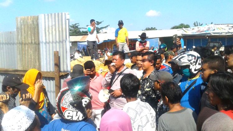 Pedagang pasar Panjang menyatakan penolakan relokasi ditengah upaya Satpol PP serta aparat lainnya bersiaga di kawasan pasar Panjang, Kota Kendari, Senin (16/7/2018). (Foto: Hasrul Tamrin/SULTRAKINI.COM)