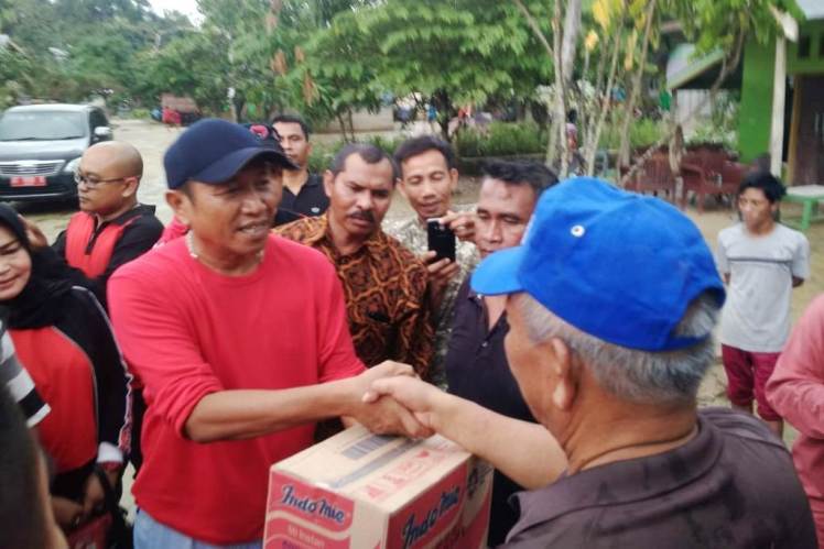 Ketua DPC PDIP Kota Kendari Ishak Ismail saat memberikan bantuan sembako kepada warga Kali Wanggu, Minggu (1/7/2018).  (Foto: La Ismeid/SULTRAKINI.COM)