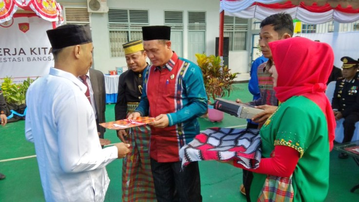 Wakil Bupati Kolaka, Jayadin melakukan penyerahan remisi secara simbolis kepada napi yang menerima remisi di pelataran Rutan Kelas II B Kolaka, Jumat (17/8/2018). (Foto: Zulfikar/SULTRAKINI.COM)