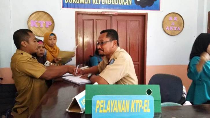 Kepala Disdukcapil Wakatobi, Abdul Rahim melakukan pelayanan di loket kepengurusan kependudukan, Selasa (25/9/2018). (Foto: Amran Mustar Ode/SULTRAKINI.COM)