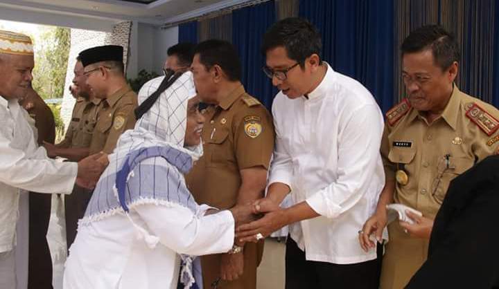 Kepala Dinas Kominfo Baubau, H. Idrus Taufik Saidi (tengah baju putih) saat menyalami salah seorang jamaah haji. (Foto: Zarmin/SULTRAKINI.COM).