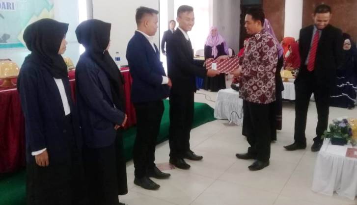 Rektor UMK, Muhammad Nur menyerahkan penghargaan kepada peserta yudisium terbaik, Senin (15/10/2018). (Foto: UMK untuk SULTRAKINI.COM)