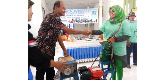Kepala Dinas Sosial Kabupaten Muna Barat, Laode Takari menyerahkan bantuan kepada perwakilan penyandang disabilitas. (Foto: Akhir Sanjaya/SULTRAKINI.COM)