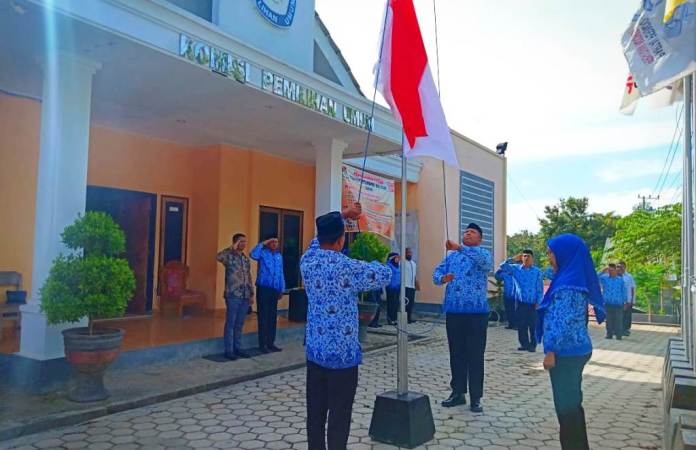 Seluruh Komisioner KPUD Muna bersama staf saat menyanyikan lagu Indonesia Raya mengiringi pengibaran Bendera Merah Putih di halaman Kantor KPUD Muna, Sabtu (22/12/2018). (Foto: Istimewa/SULTRAKINI.COM)