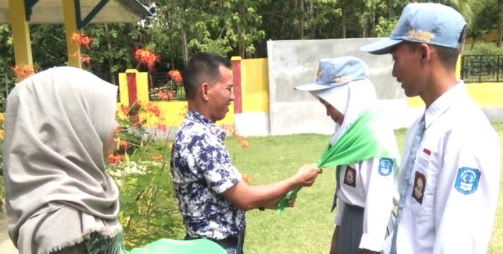 Pemasangan Slayer oleh Kepala SMKN 1 Polinggona, Eko Prayudi Anwar kepada siswa pencinta alam angkatan pertama. (Foto: Dok.SULTRAKINI.COM)
