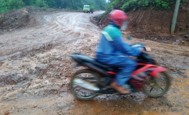 Pengendara roda dua melintasi jalur penghubung tiga desa di Kecamatan Molawe. Kabupaten Konawe Utara yang rusak akibat aktivitas kendaraan tambang. (Foto: Dok.SULTRAKINI.COM)