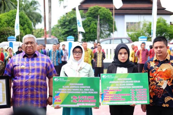 Gubernur Sultra, Ali Mazi, saat memberikan santunan jaminan sosial kecelakaan kerja kepada ahli waris penerima santunan, Kamis (7/2/2019). (Foto : Hasrul Tamrin/SULTRAKINI.COM)