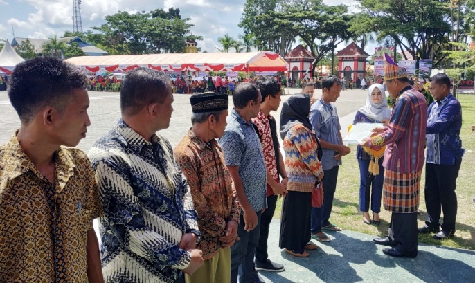 Bupati Kolaka, Ahmad Safei saat menyerahkan sertifikat tanah program PTSL, Kamis (28/2/2019). (Foto: Zulfikar/SULTRAKINI.COM).