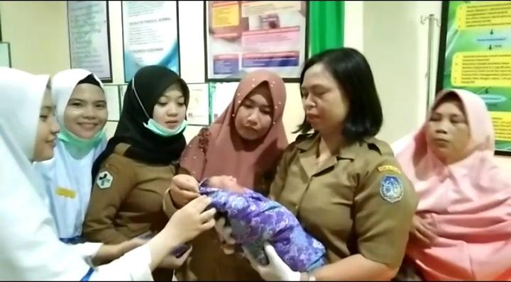 Pegawai Puskesmas Pomalaa menggendong bayi yang ditemukan di pos kambling Dusun Tiga Lomboato, Desa Sopura, Kecamatan Pomalaa, Kabupaten Kolaka, Senin (4/3/2019). (Foto: Dok.SULTRAKINI.COM)