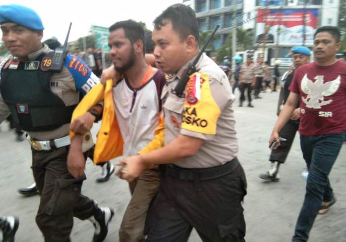 Ketua BEM UHO, Maco, dipegang oleh polisi saat diamankan di Polda Sultra. (Foto: La Niati/SULTRAKINI.COM).