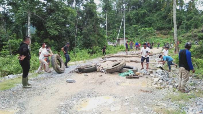 Sejumlah warga di Kecamatan Moramo, Kabupaten Konawe Selatan menutup jalur perlintasan kendaraan alat berat milik PT PT Dimas Indomineral Lampung menggunakan kayu, batu, dan ban bekas, Senin (1/4/2019). (Foto: Istimewa)