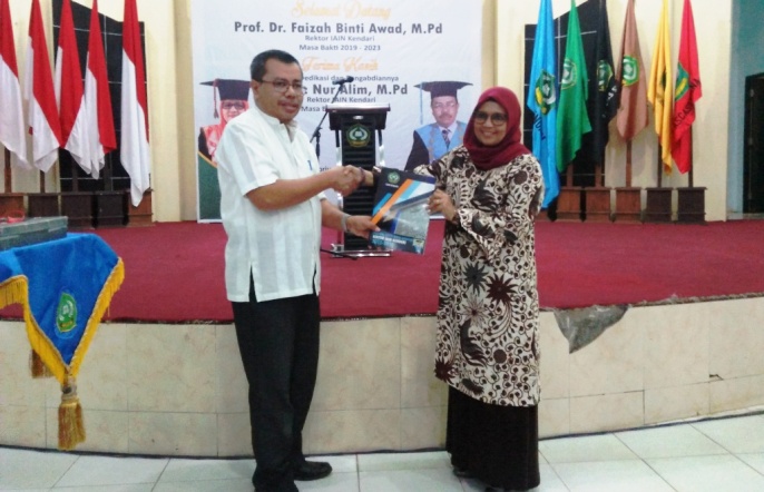 H Nur Alim, rektor sebelumnya saat menyerahkan kenangan-kenangan kepada Faizah Binti Awad rektor IAIN Kendari. (Foto: Muh Yusuf /SULTRAKINI.COM).