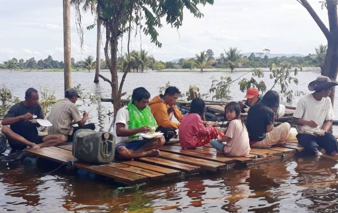 Korban Banjir di Kecamatan Wonggeduku sedang menikmati bantuan makanan siap saji, Senin (17/6/2019) (Foto: Istimewa)