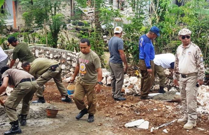Nampak Anggota Satpol PP Buton yang dipimpin langsung oleh Kasatpol PP, Juriadin saat mengerjakan pembangunan rumah warga di Desa Gunung Jaya. (Foto: La Ode Ali/SULTRAKINI.COM).