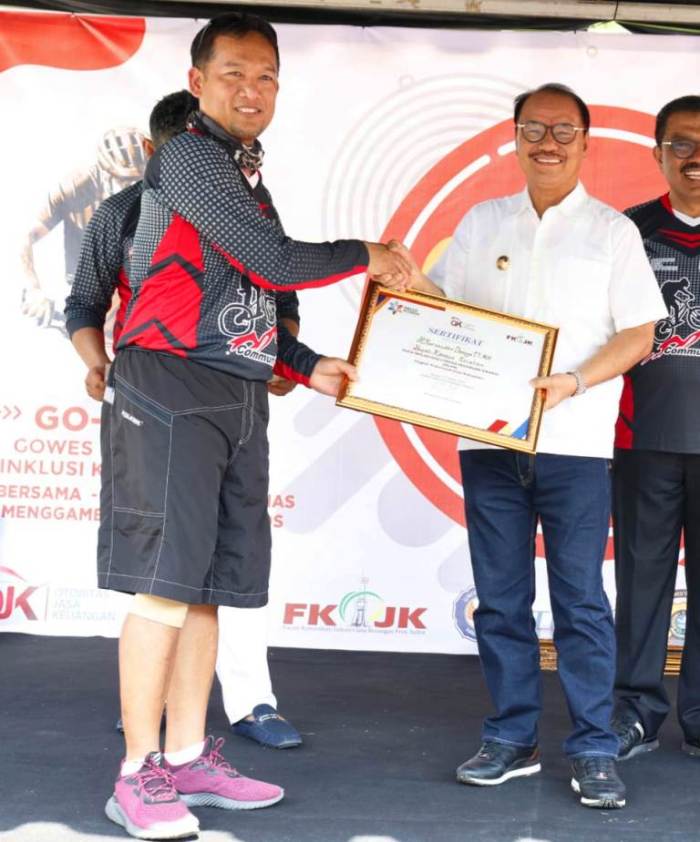 Bupati Konsel Surunuddin Dangga saat menerima sertifakat penghargaan dari Kepala OJK Sultra (Foto: Istimewa)
