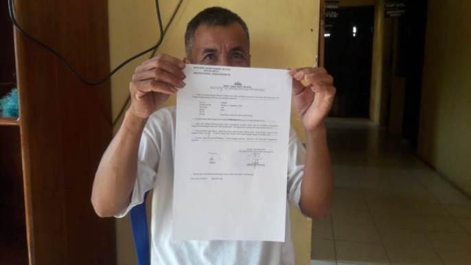 Rahman (50), saat memperlihatkan surat laporan di Polsek Angata, Jumat (18/10/2019). (Foto: La Ode Risman Hermawan/SULTRAKINI.COM).