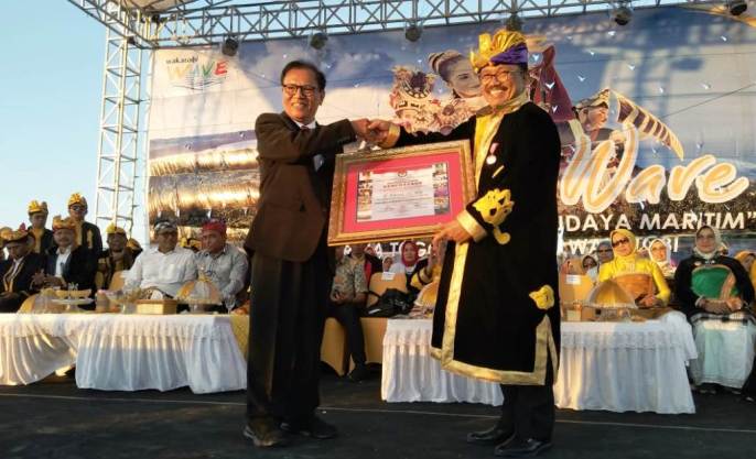 Ketua Lembaga Kebudayaan Nasional Indonesia Totok Sudarwoto, menyerahkan sertifikat penghargaan ke Bupati Wakatobi, Arhawi. (Foto: Amran Mustar Ode/SULTRAKINI.COM). 