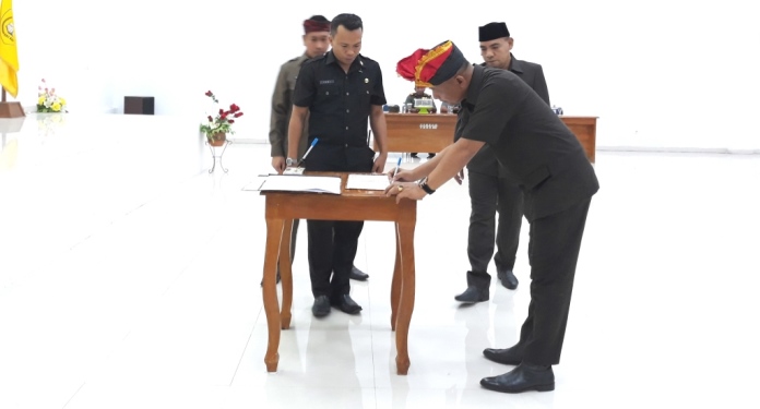 Sekda Baubau Roni Mukhtar menandatangani surat kesepahaman KUA PPAS APBD Tahun 2020 antara Pemkot dengan DPRD Kota Baubau, Jumat (8/11/2019). (Foto: Aisyah Welina/SULTRAKINI.COM)