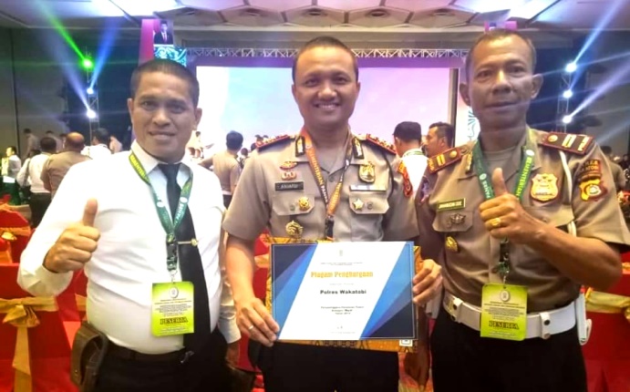 Kapolres Wakatobi, AKBP Anuardi memegang penghargaan pelayanan publik kategori baik dari Kemenpan RB dan didampingi oleh Kasat Intel Polres Wakatobi (sebelah kanan), dan Kasat Lantas Polres Wakatobi (sebelah kiri). (Foto: Istimewa)