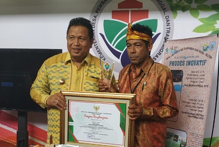 Kepala Desa Lakandito Jafarudin (kanan) foto bersama Bupati Muna Rusman Emba usai menerima piagam penghargaan dari Kemendes PDTT. Foto: IST