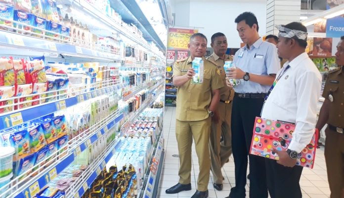 Sekretaris Kota, Roni Mukhtar menunjukan tanggal kedaluwarsa produk minuman di supermarket. (Foto: Aisyah Welina/SULTRAKINI.COM)