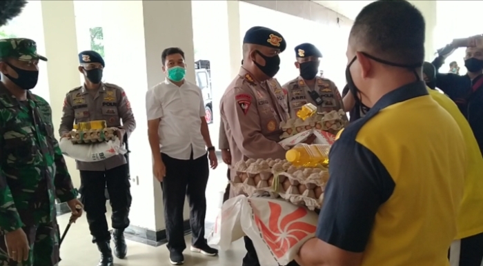 Satuan Brimob Polda Sultra saat menyerahkan bantuan paket sembako kepada warga yang membutuhkan di Bandara, Jumat (01/04/2020) (Foto : Riswan/SULTRAKINI.COM)
