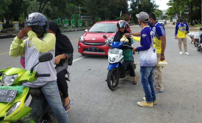 Anggota IMI Sultra saat membagikan takjil gratis pada pengguna jalan, (Foto: Hasrul Tamrin/SULTRAKINI.COM)