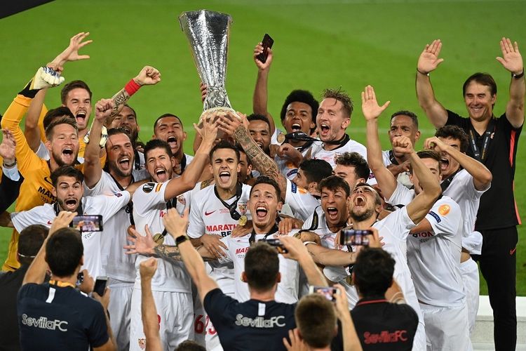 Para pemain Sevilla merayakan dengan trofi setelah memenangkan pertandingan final sepak bola UEFA Europa League Sevilla v Inter Milan pada 21 Agustus 2020 di Cologne, Jerman barat.(AFP/INA FASSBENDER)