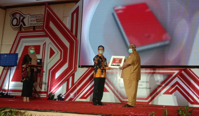 Kepada OJK Sultra, Mohammad Fredly Nasution, menyerahkan secara simbolis Buku Saku Esa kepada Gubernur Sultra Ali Mazi, (Foto: Wa Rifin/SULTRAKINI.COM)
