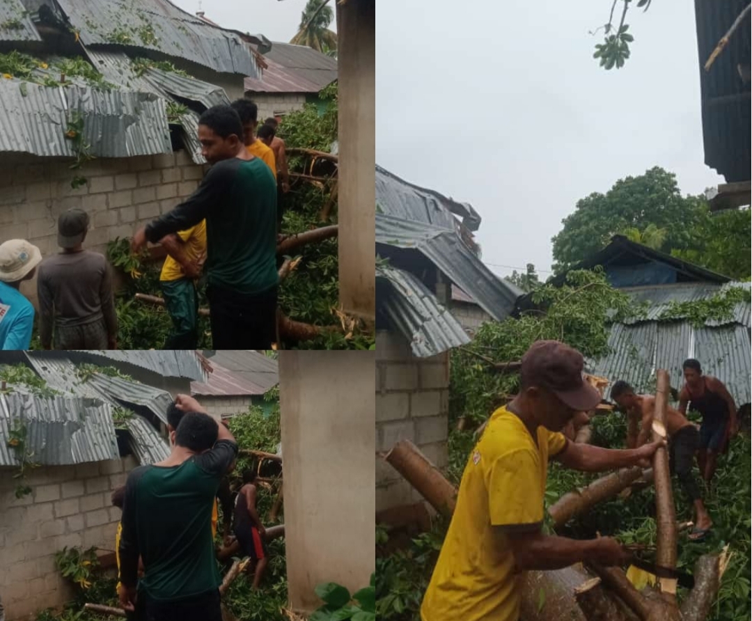 Sejumlah warga gotong royong membersihkan pohon roboh yang menimpah rumah warga (Foto: Ist)