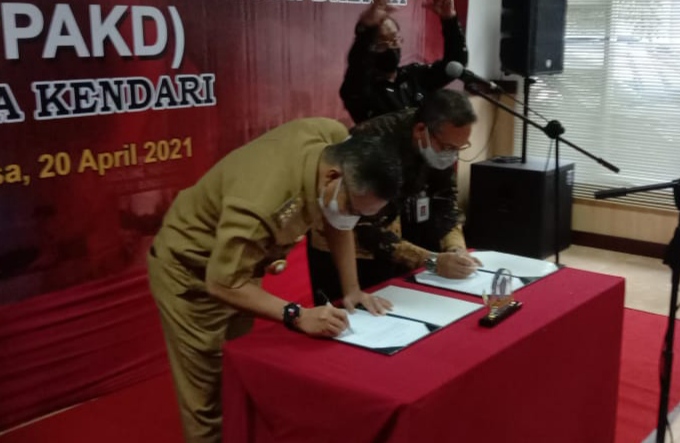 Wali Kota Kendari Sulkarnain Kadir dan Kepala OJK Sultra Mohammad Fredly Nasution menandatangani SK pengukuhan pengurus TPAKD Kota Kendari, (Foto: Wa Rifin/SULTRAKINI.COM)