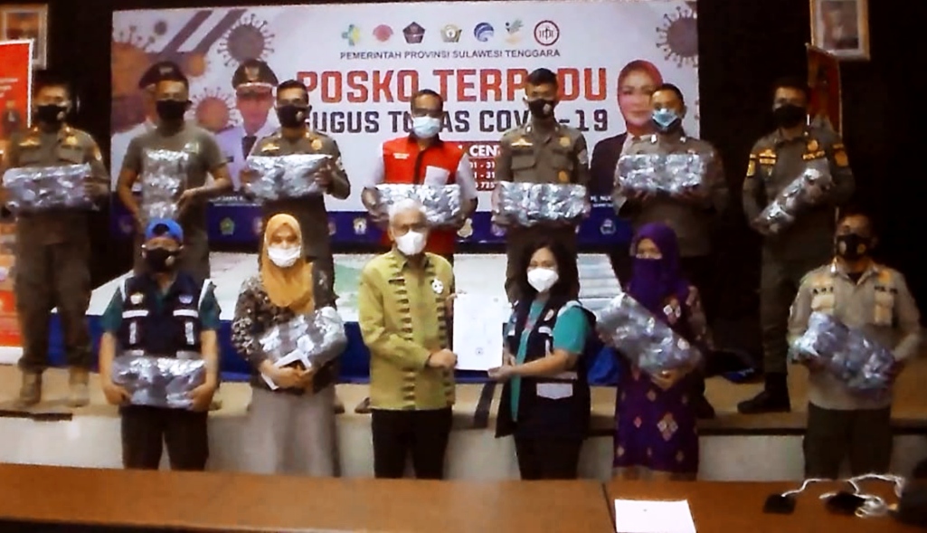Koordinator Perubahan Perilaku Sultra, Asrun Lio menyerahkan masker untuk didistribusikan, (Foto: Hardiyono Zimani/SULTRAKINI.COM)
