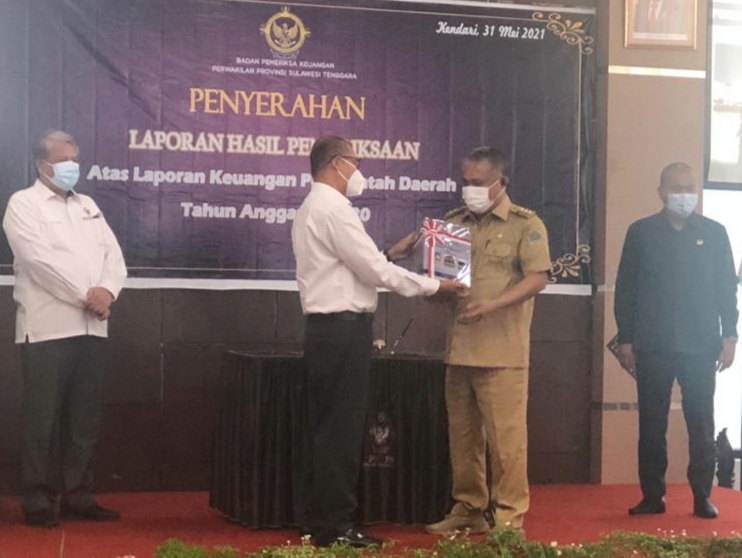 Bupati Konawe, Kery Saiful Konggoasa saat menerima LHP LKPD Pemkab Konawe tahun 2020 yang diserahkan Kepala BPK RI Perwakilan Sultra Andi Sonny, (Foto: Humas dan Protokol Pemda Konawe) ﻿