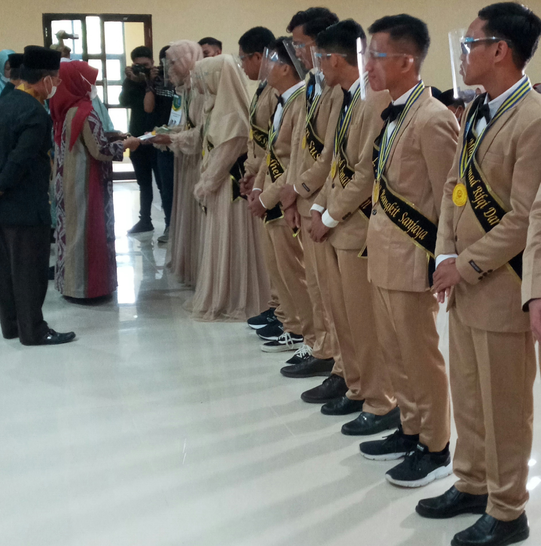 Sekertaris Daerah Kota Kendari menyerahkan penghargaan kepada lulusan terbaik, (Foto: Al Iksan/SULTRAKINI.COM)
