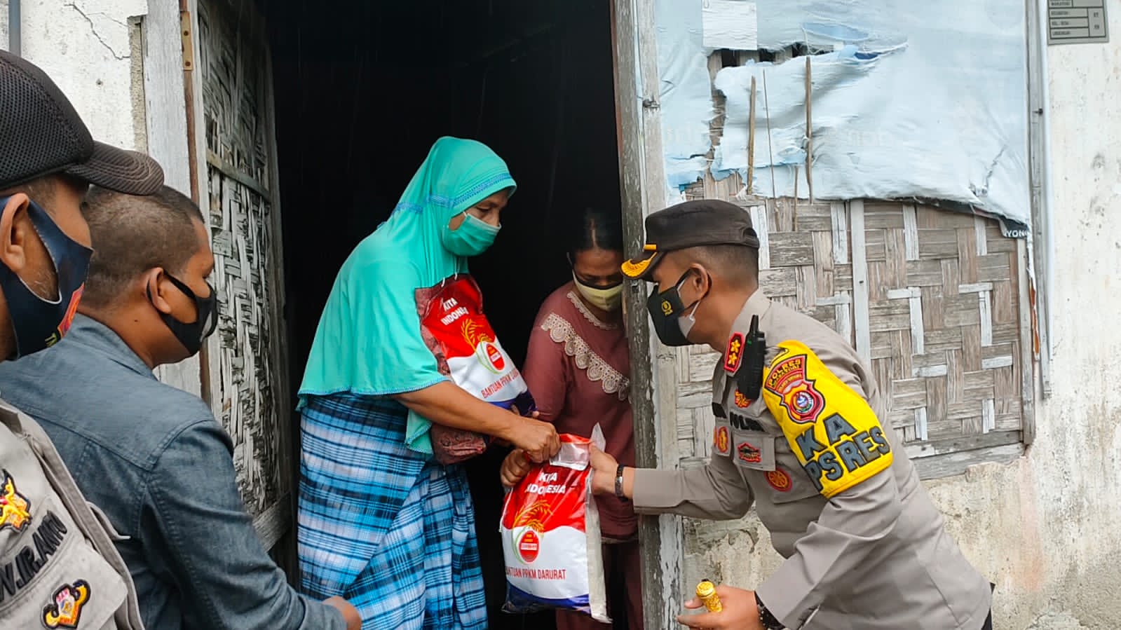 Kapolres Wakatobi, AKBP Suharman Sanusi, dan Perwira penghubung (Pabung) TNI-AD Wakatobi, Mayor Arham Katili saat menyalurkan paket sembako kepada masyarakat. (Foto: Ist)