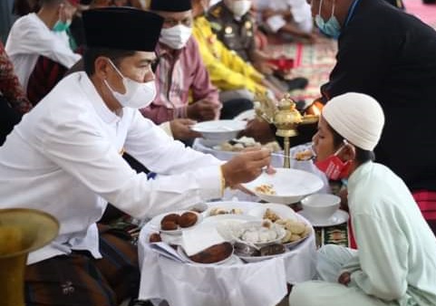 Bupati Buton La Bakry memberi makan anak yatim piatu pada acara Pakande Ana-ana Maelu,. Foto: IST.